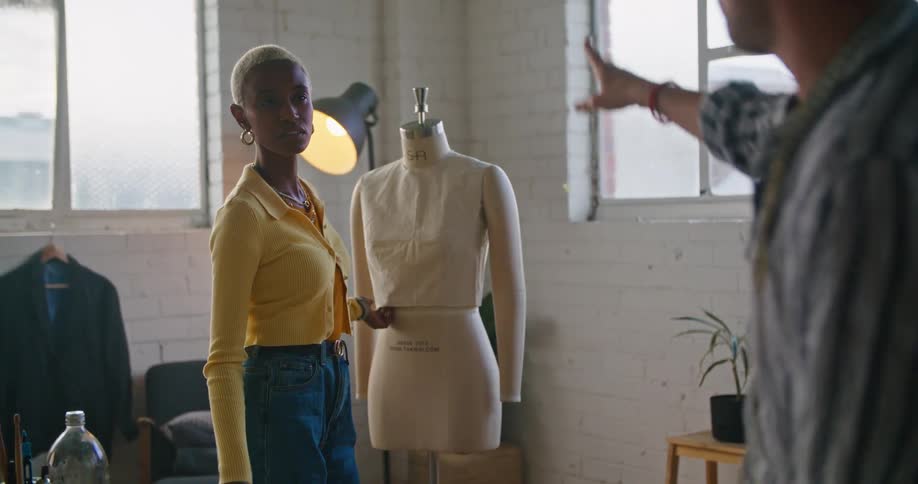 Two coworkers working together on clothing