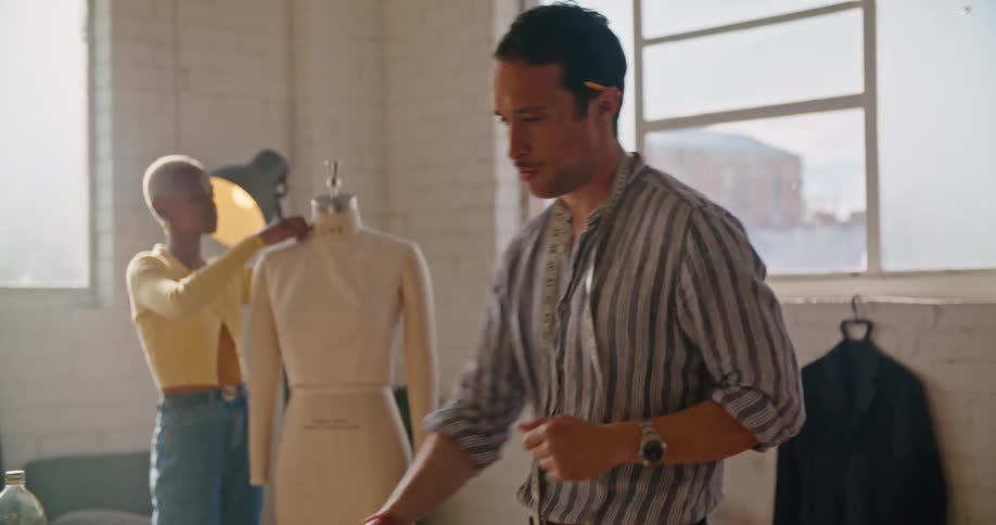 Clothing designers are looking at material and brainstorming ideas in a studio