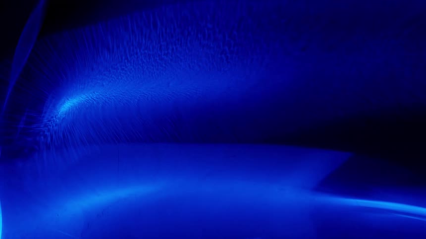 Blue colors swirl around in the dark