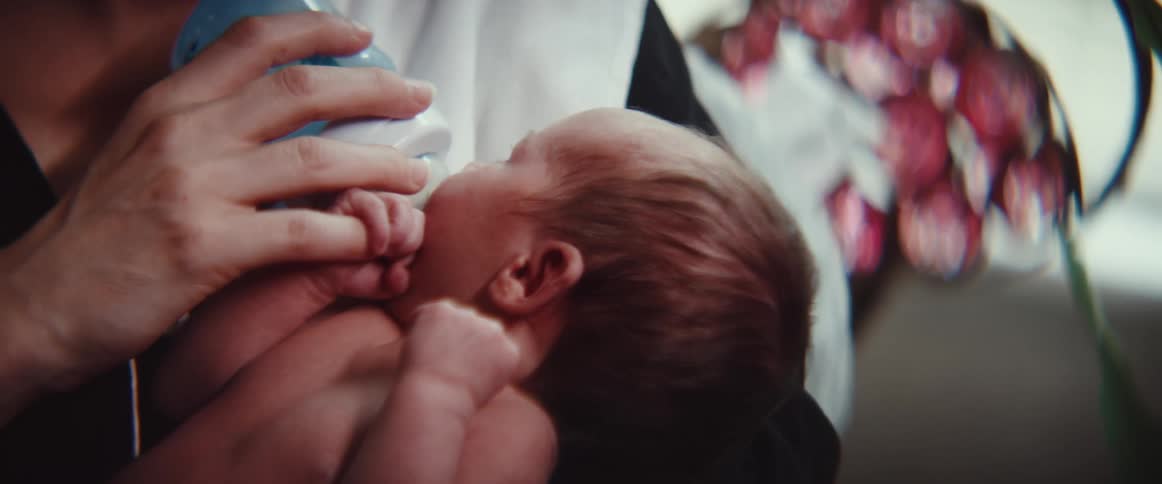 A baby is being fed from a bottle