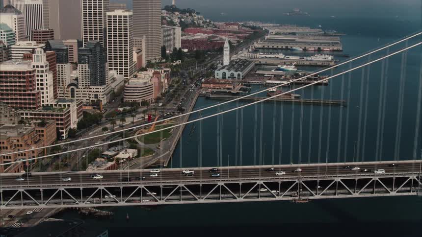 Aerial view of suspension bridge with vehicles crossing to city