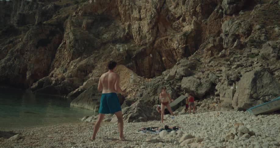 A man and woman play badminton on the beach