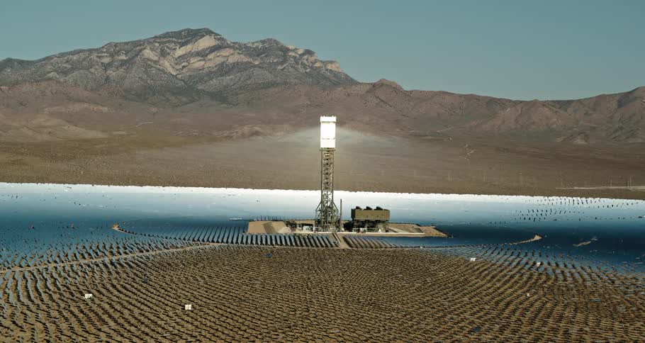 A large utility tower sits in front of a mountain range