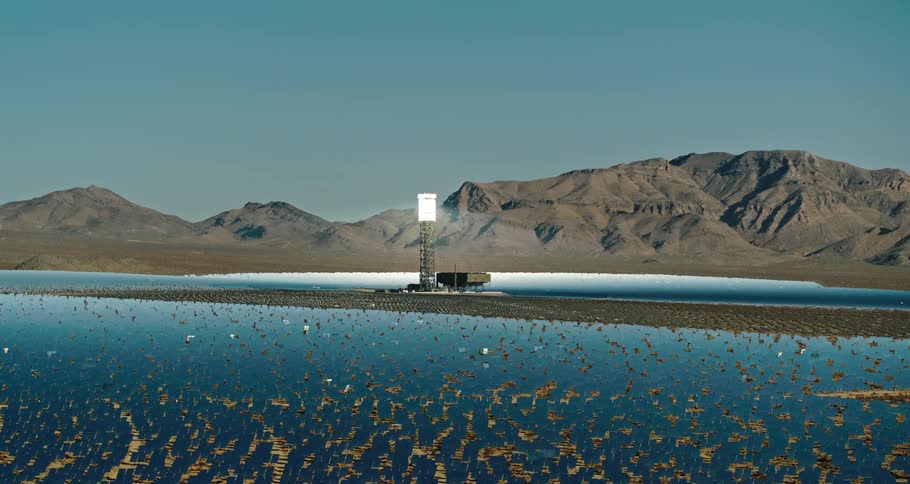 A landscape with solar reflectors a mountain range the sky and clouds in the background