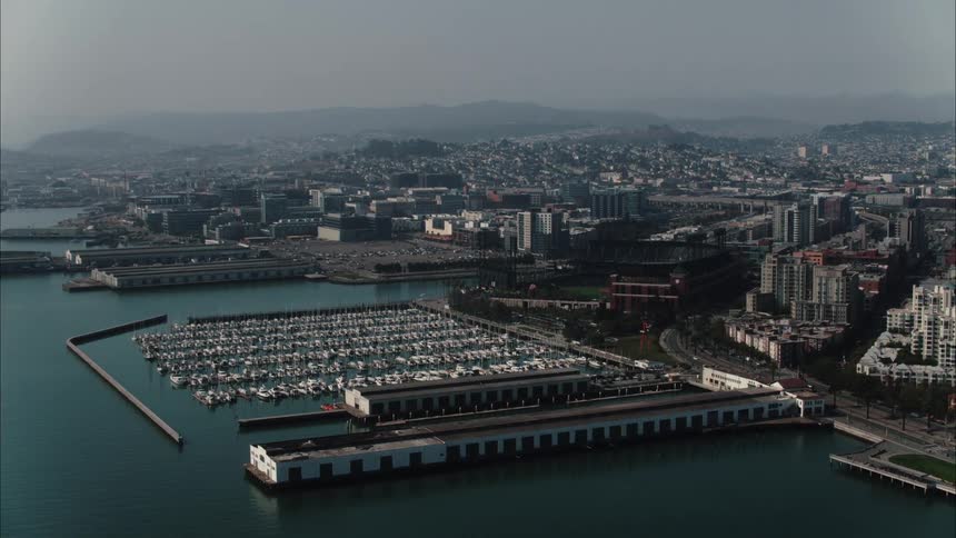 Aerial view of boats docked on a marina close to a waterfront city
