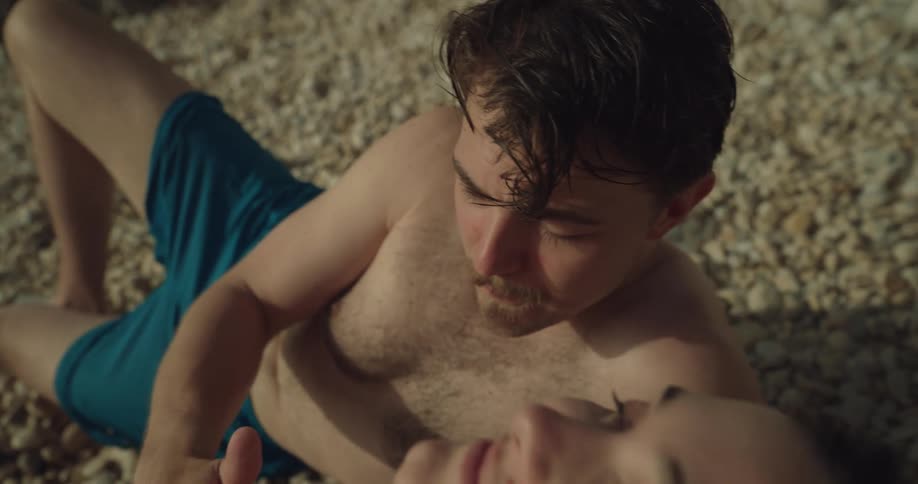 A man is putting sunscreen lotion on a womans chest in a heart shape