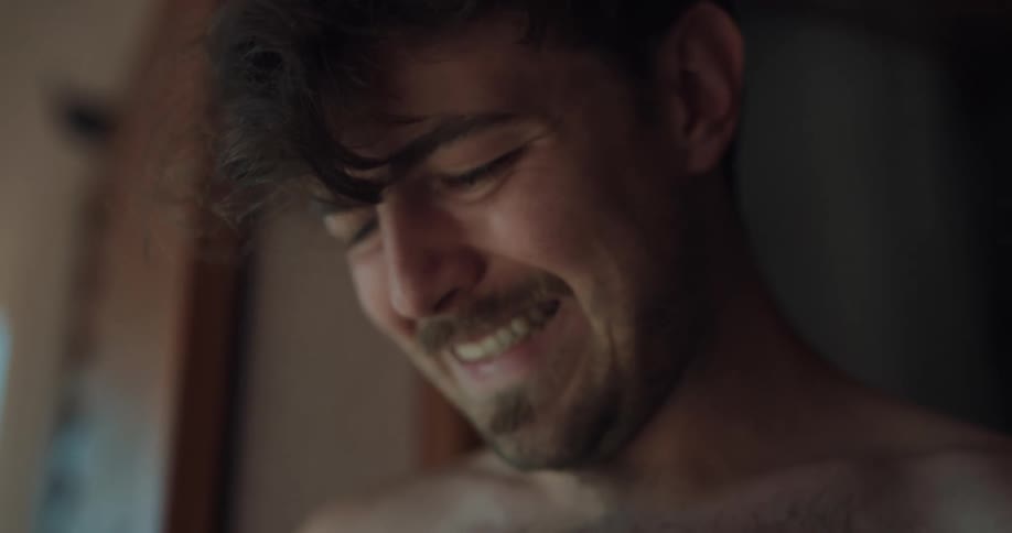 A man in a room with a wall in the background