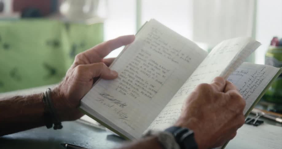 A man flips through a notebook filled with handwritten notes
