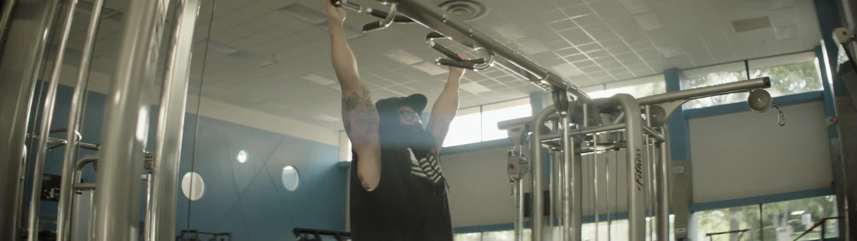 A man is doing pull ups in a gym