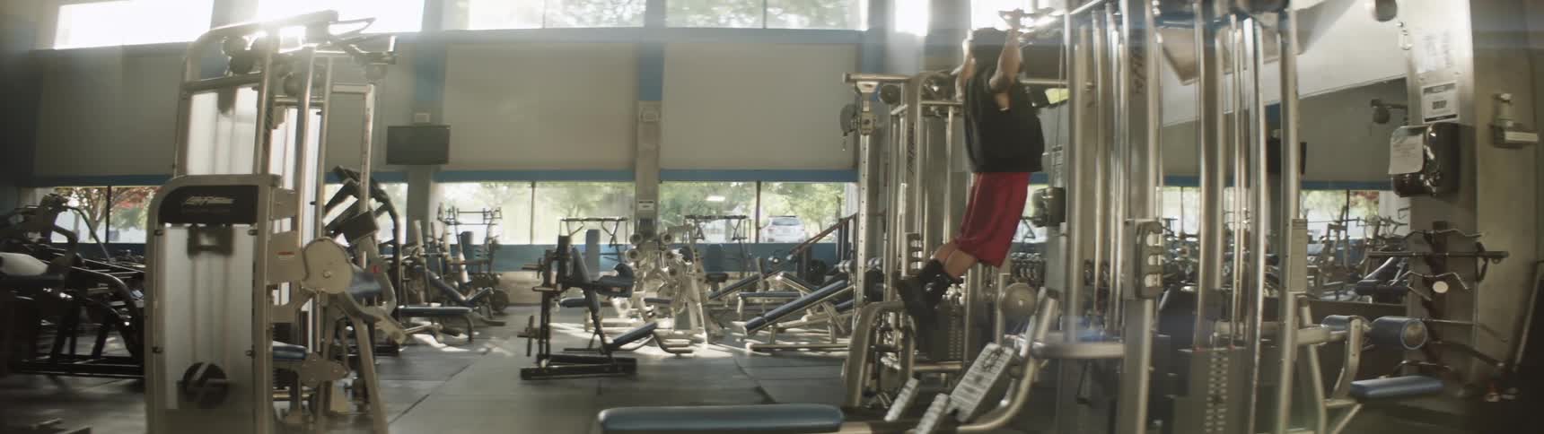 A man does pull ups in a gym