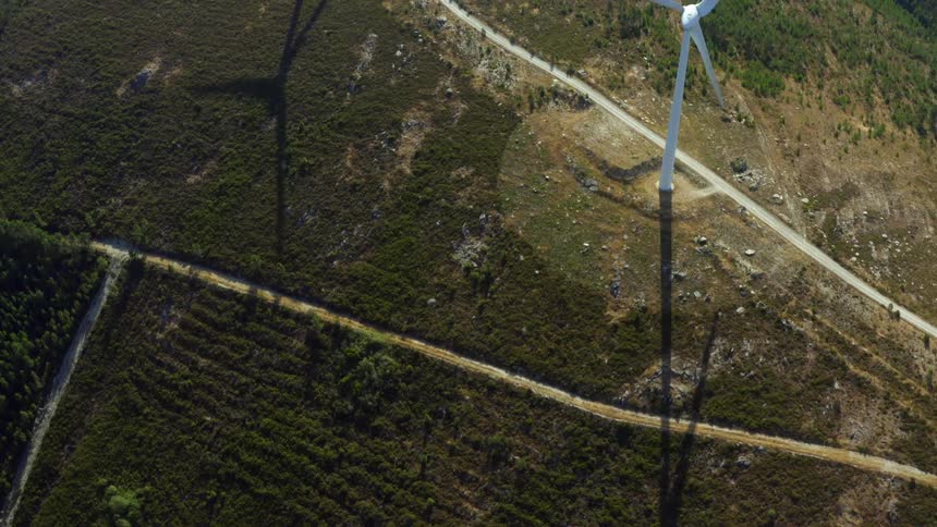An aerial view flying over windmills