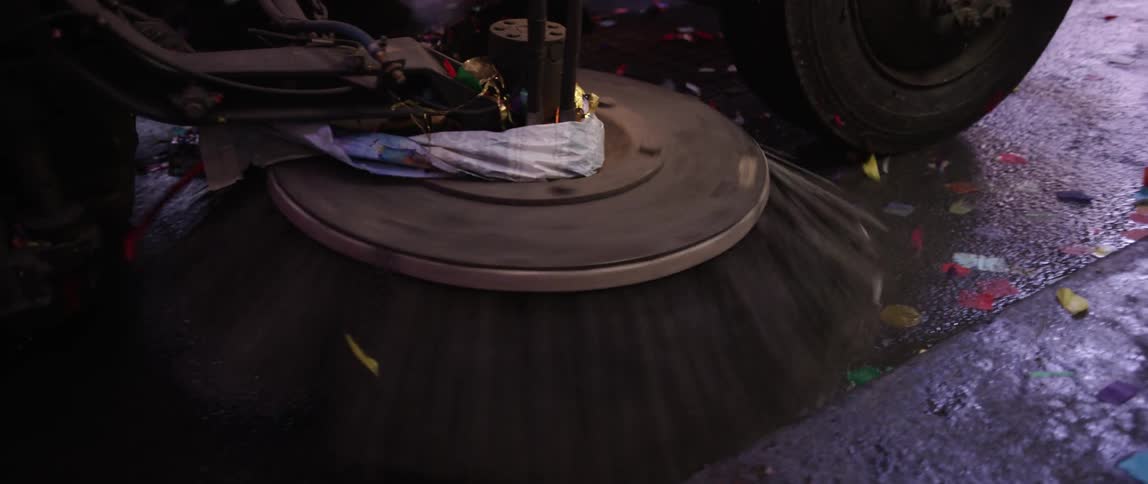 The bristle on a street sweeper cleans a curb