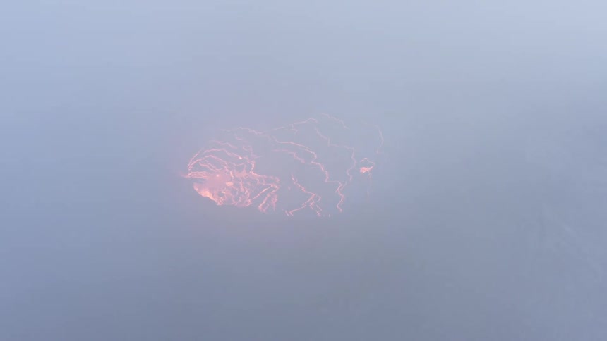 Thick smoke fills the air as lava glows inside a volcano