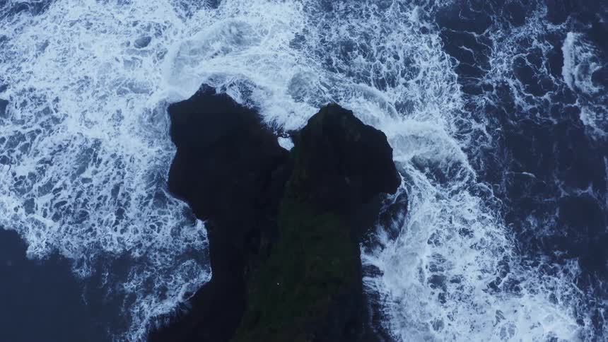 Strong ocean waves crash onto a promontory