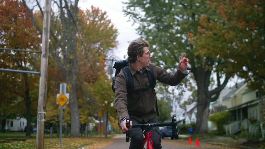 A man riding a bicycle around a neighborhood