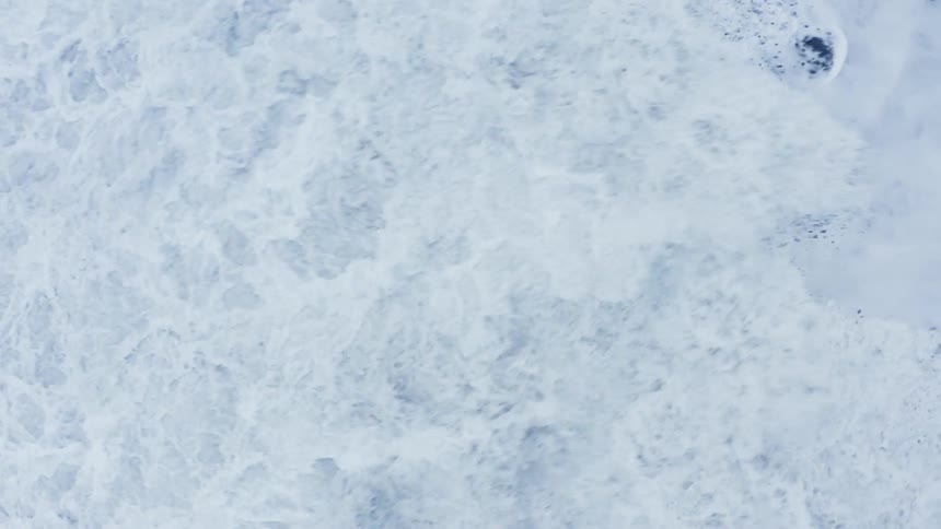 Foamy wave breaks against the shore