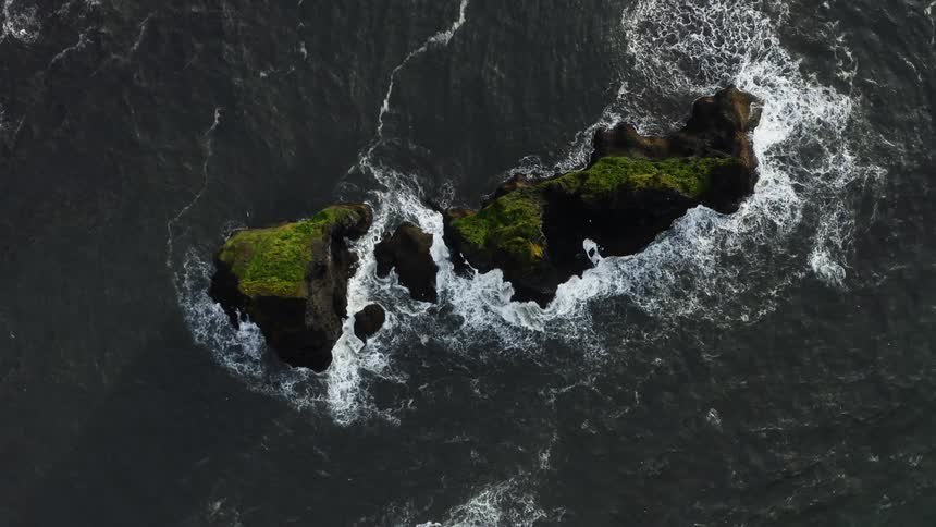 Waves splash over a rocky island
