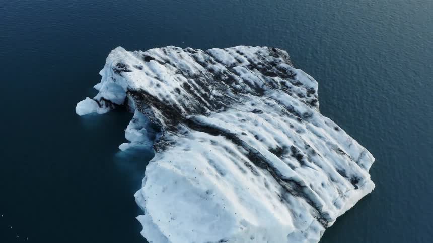 A glacier with snow and ice surrounded by water