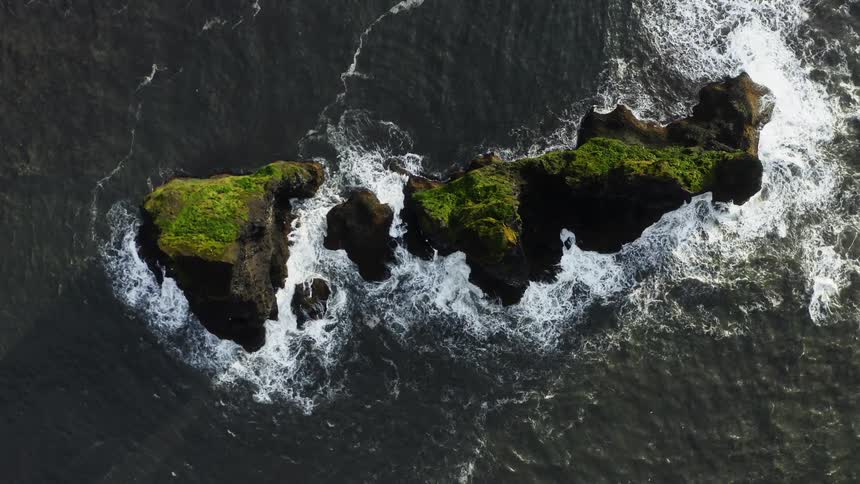 Waves splash over a rocky island
