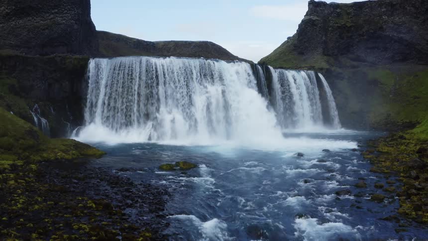 A waterfall spans an entire canyon