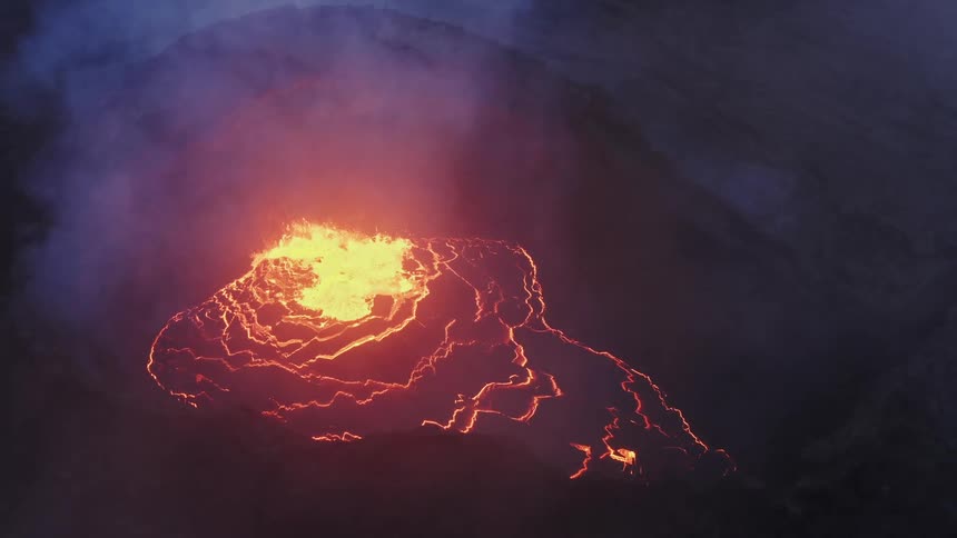 Smoke fills the air as lava erupts from a volcano
