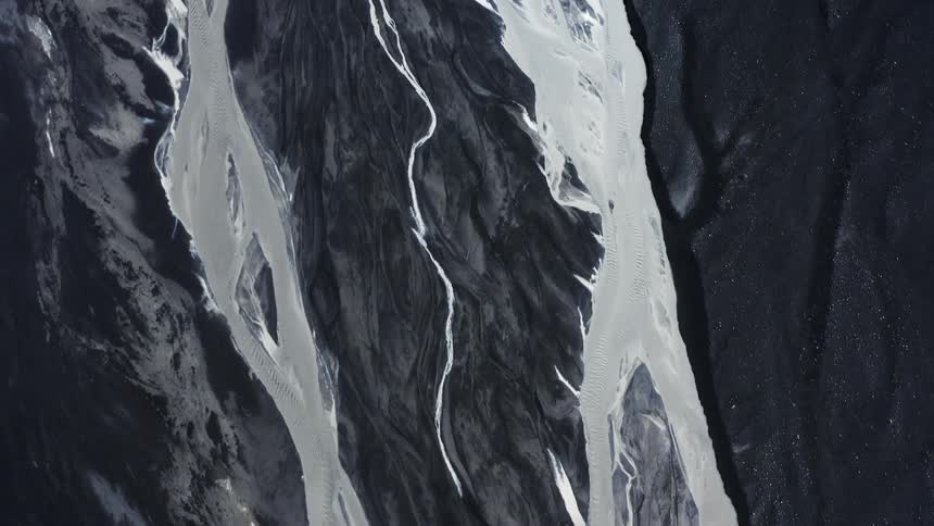 A high altitude aerial view of mountains and their water channels