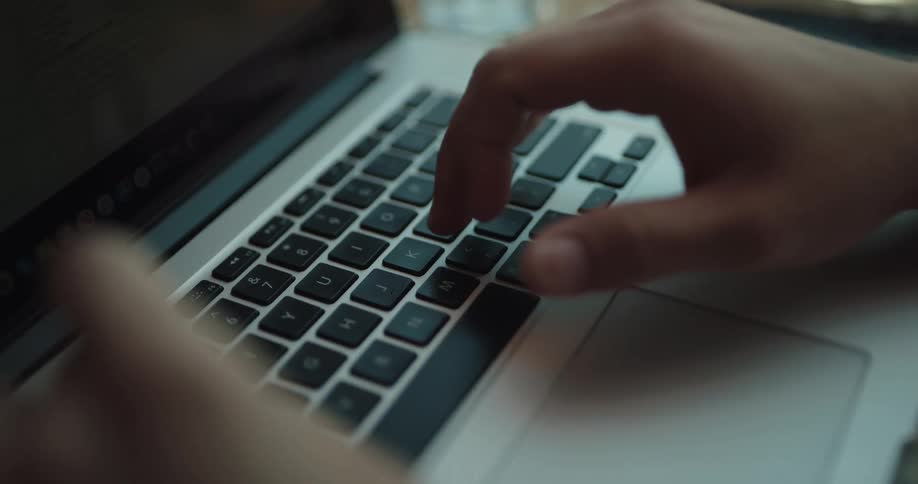Close up of man s hands typing on laptop keyboard