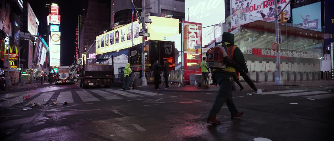 A man in a backpack walks down a street