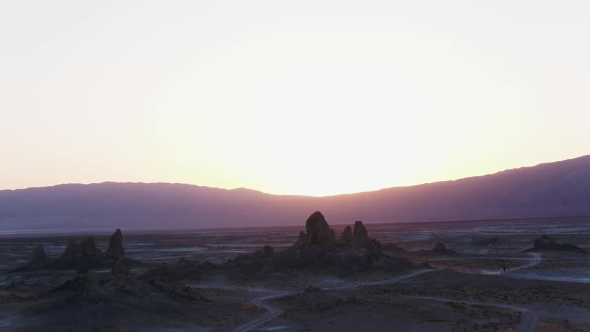 Rock formations across the land and mountains in the distance
