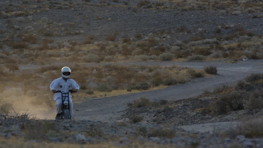Two people riding dirt bikes outdoors