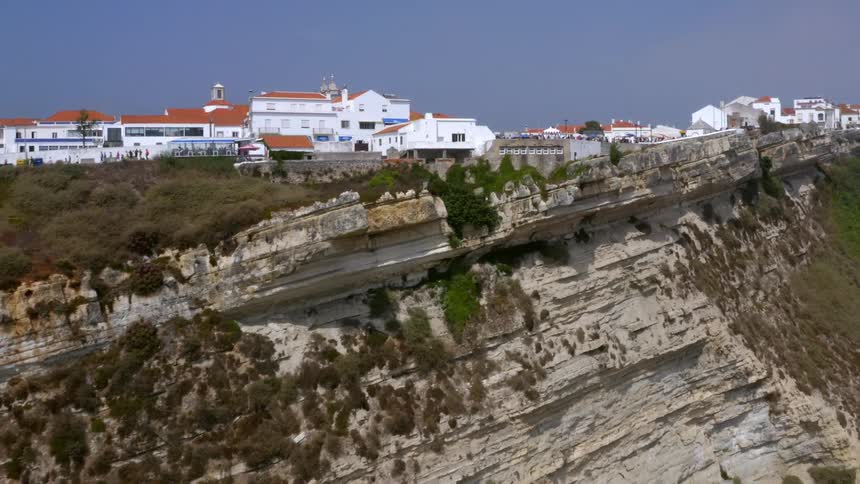 A city on the edge of a cliff under a clear sky