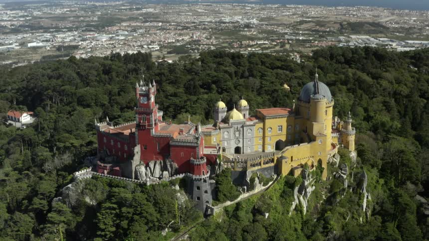 The colorful pena palace on a tree covered hill with sintra portugal below