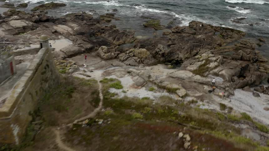 An old abandoned fort surrounding by a wall is on an island in the ocean