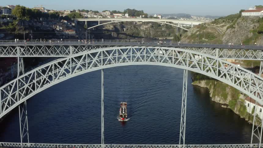 Aerial view of two bridges over river connecting city cliffs with houses