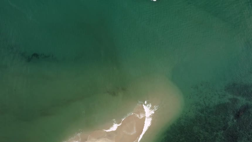 A view down onto the ocean and a beach