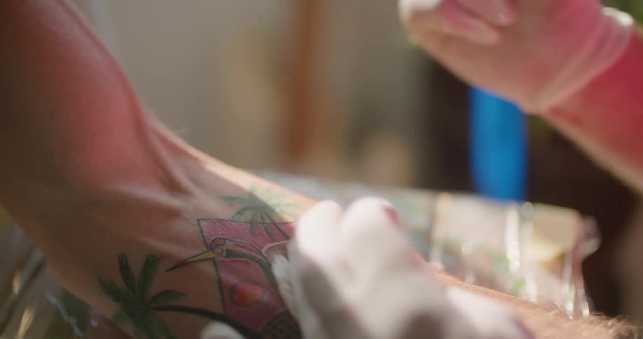 A tattoo artist tattoo a mans arm