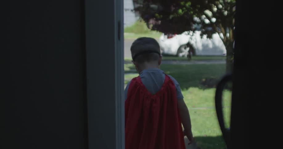 A boy walks outside from his home