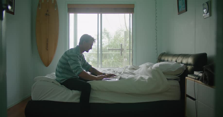 A man sitting on a bed relaxing