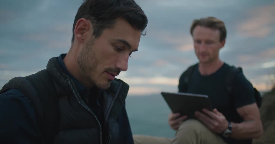 Two men outside taking notes