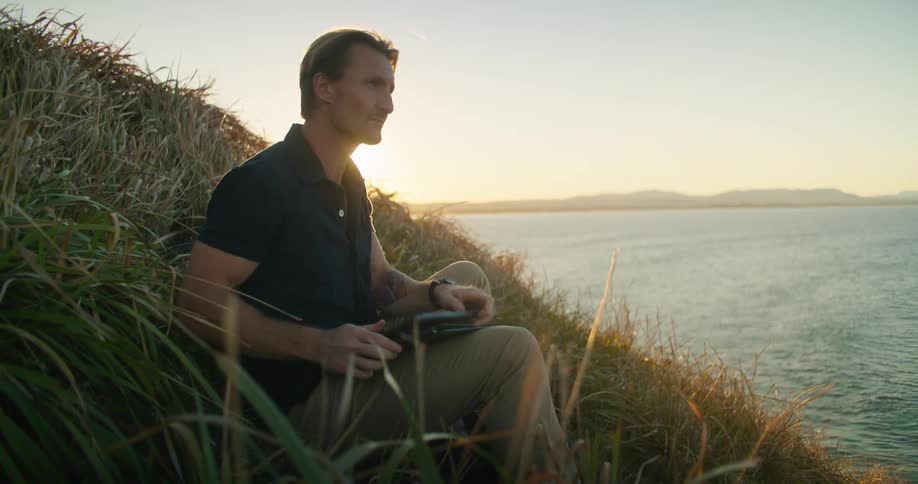 A man looking at the ocean through binoculars
