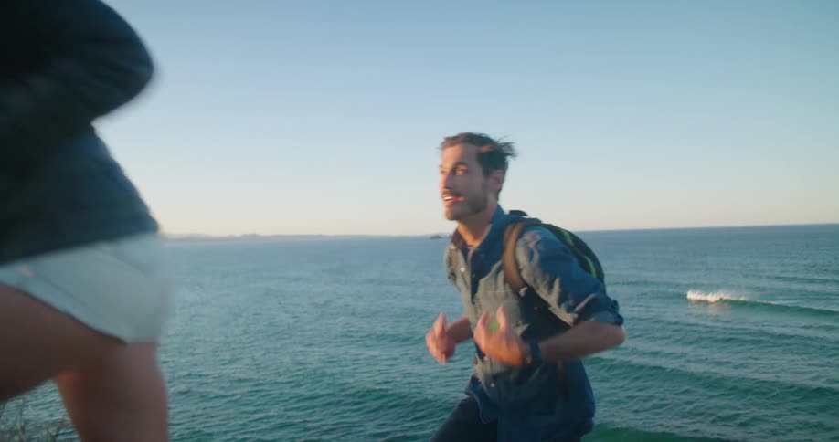 A man and woman hike on the beach