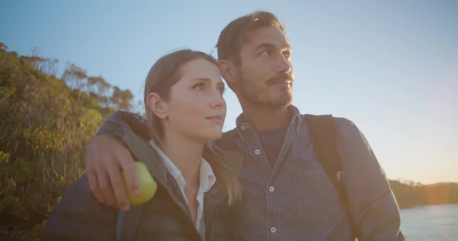 A man and woman are standing near the waterfront
