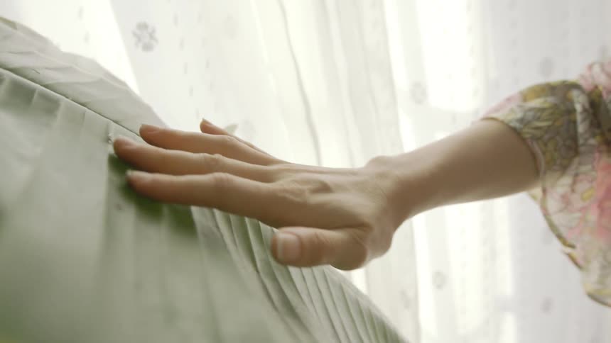 A woman is rubbing the large plant leaf