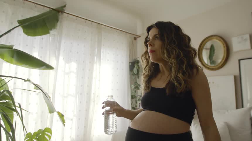 A woman drinks from a water bottle