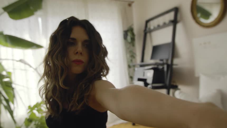 A pregnant woman is doing exercises holding out her arms