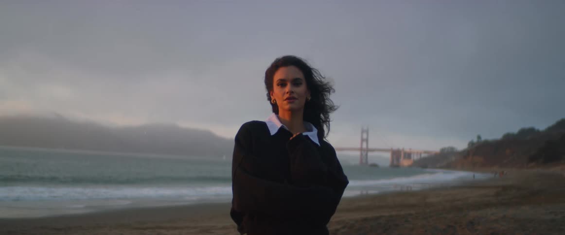 A woman is posing on the windy beach
