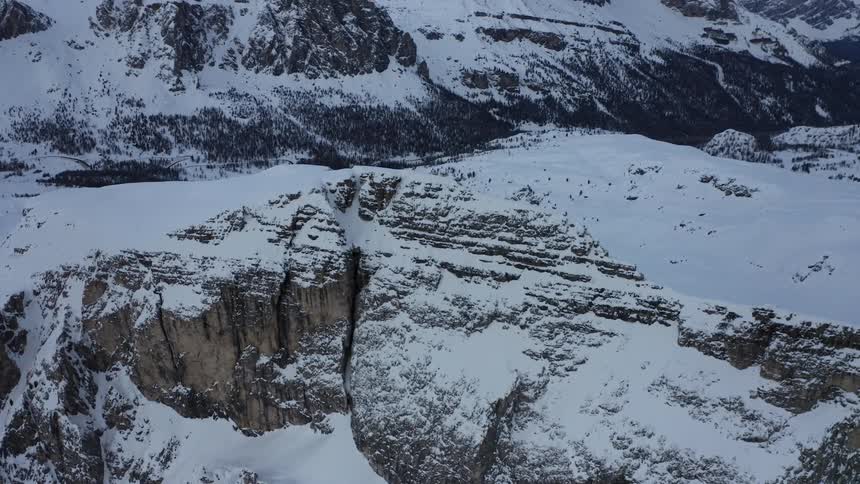 Snow covered mountains and rocks under a cloudy sky