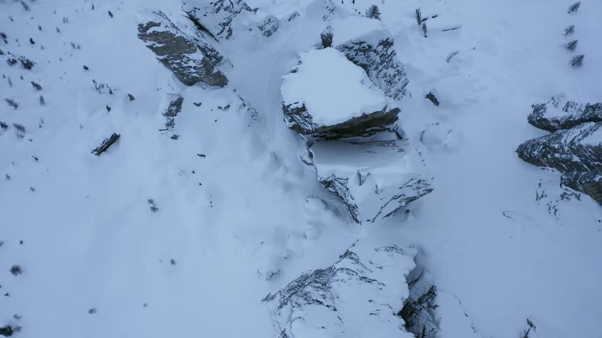 An aerial view of a mountain range with snow on it