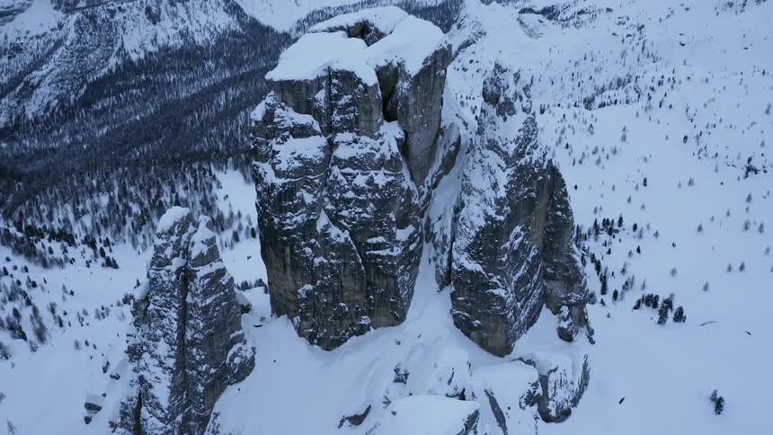 An aerial view of a mountain range with snow all over it