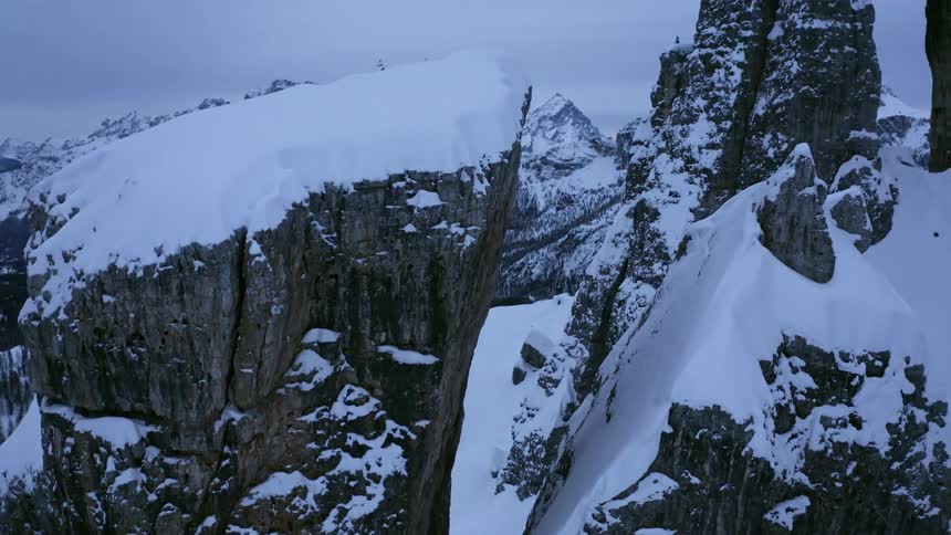 Aerial view of high snowy mountain ridge under cloudy sky